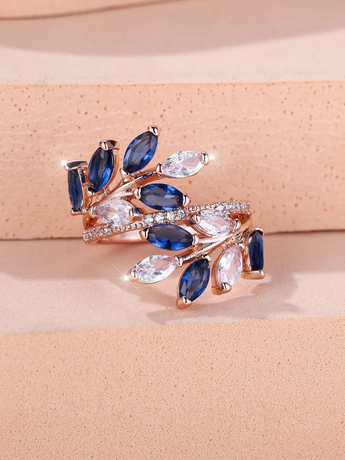 Adjustable copper leaf ring in platinum or rose gold finish on a white background