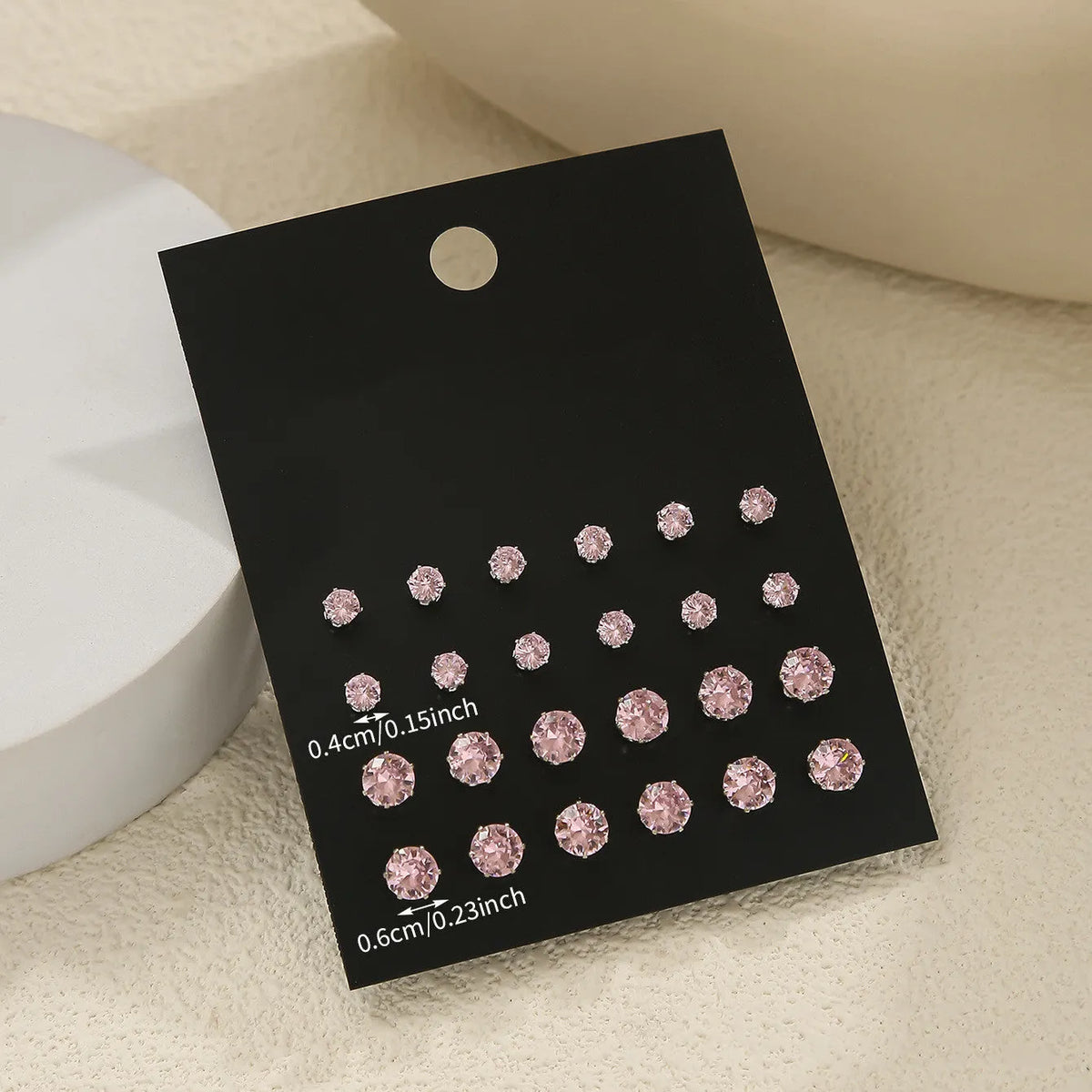 Pink round women's earrings set of 12 pairs on display, alloy with electroplated finish, geometric stud style