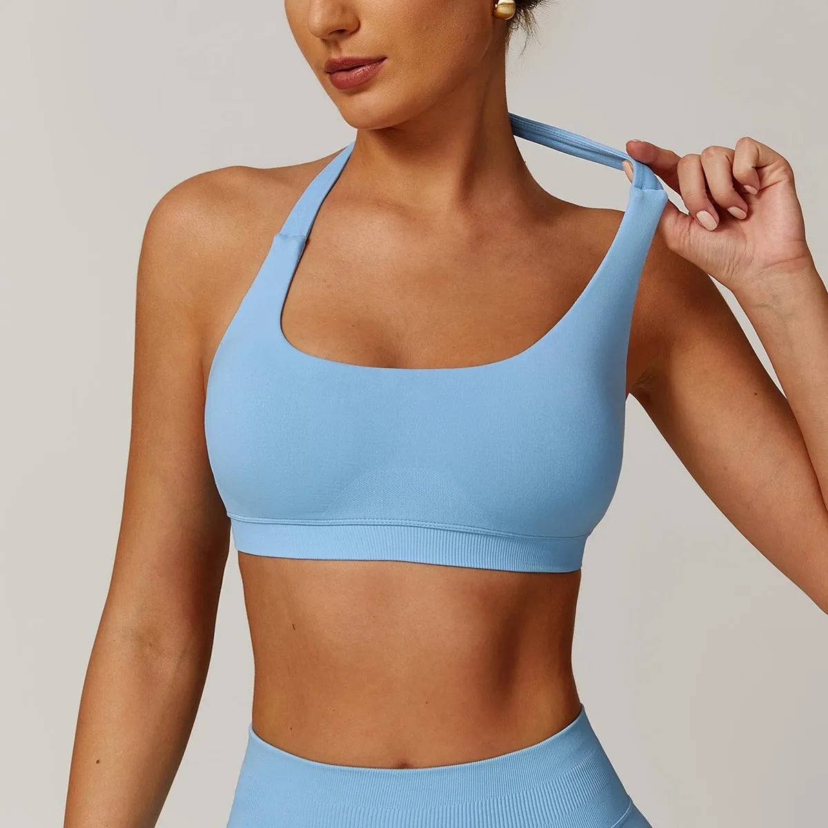 Women's black halter style yoga bra with medium support and hollow design.