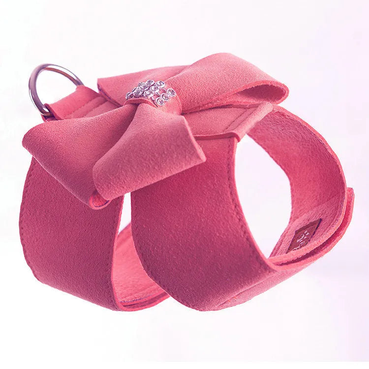 Pink microfiber dog harness with a large bowknot on the chest, shown alongside blue and orange colour options.