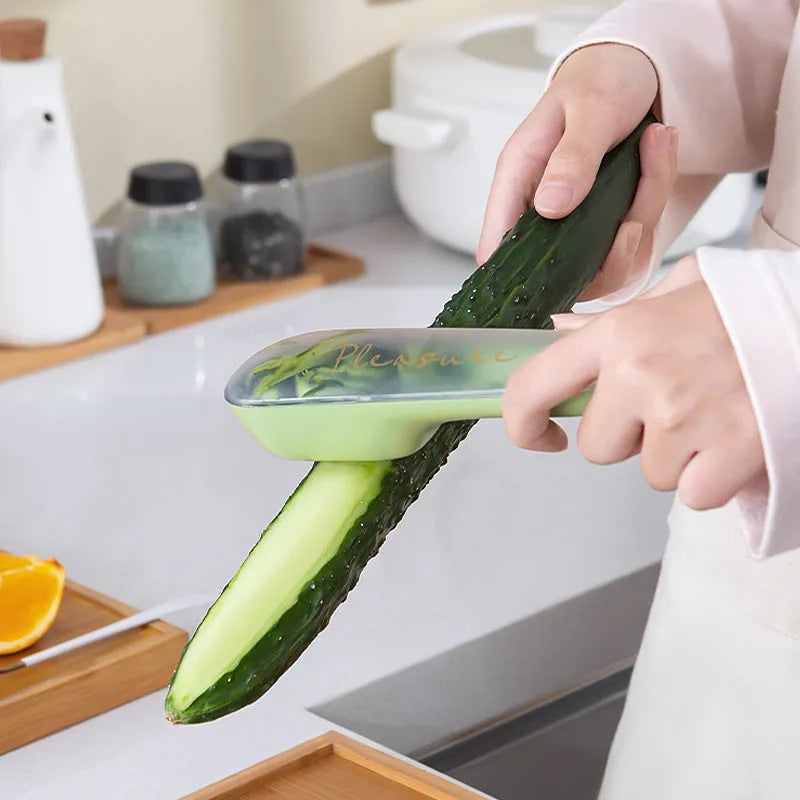 Green kitchen peeler with stainless steel blade stored inside a clear plastic tube.