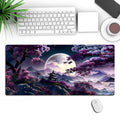 Large rectangular black gaming mouse pad with detailed pattern, shown on a desk with a keyboard.