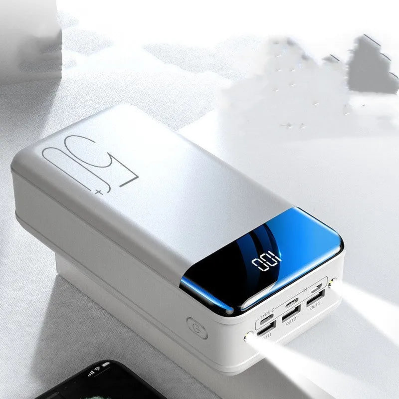 Black and white large 50000mAh power bank with three USB ports showing size scale