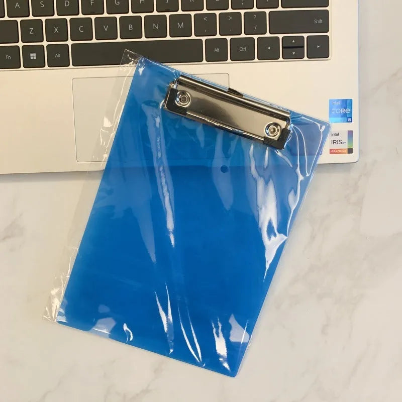 A4 transparent plate holder writing board with metal clip, shown in blue on a desk.