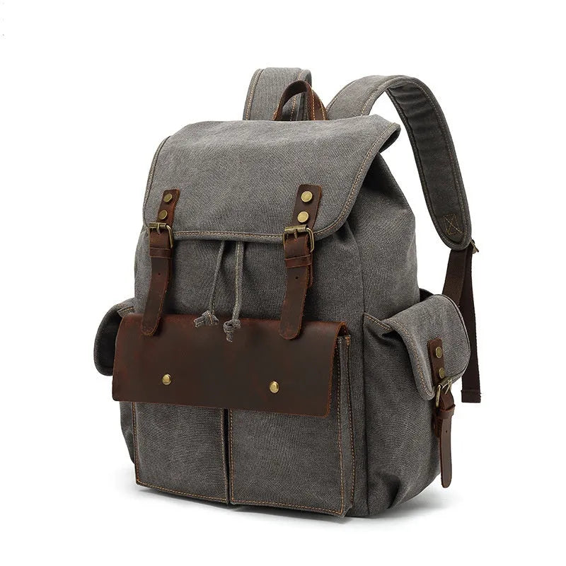 Retro military green canvas backpack with antique bronze hardware on a plain background.