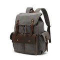 Retro military green canvas backpack with antique bronze hardware on a plain background.
