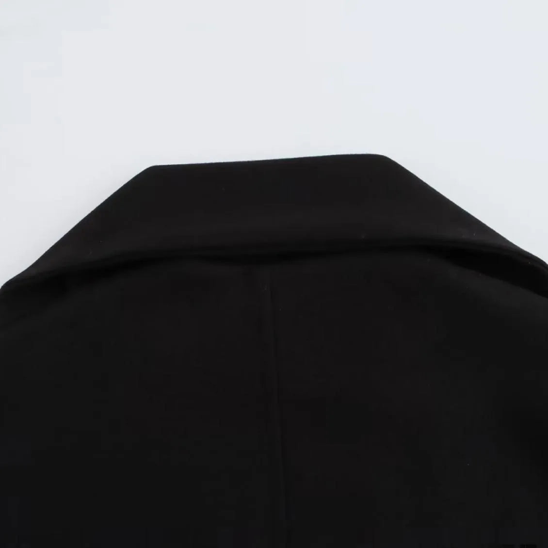 Women's long grey coat with an artificial fur collar, shown with pockets and a street fashion style.