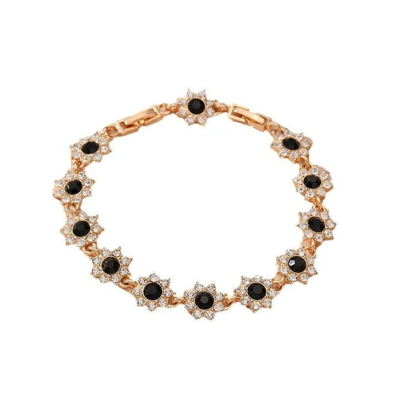 Gold and silver flower bracelet with colourful crystal and simulated diamond stones on a wrist.