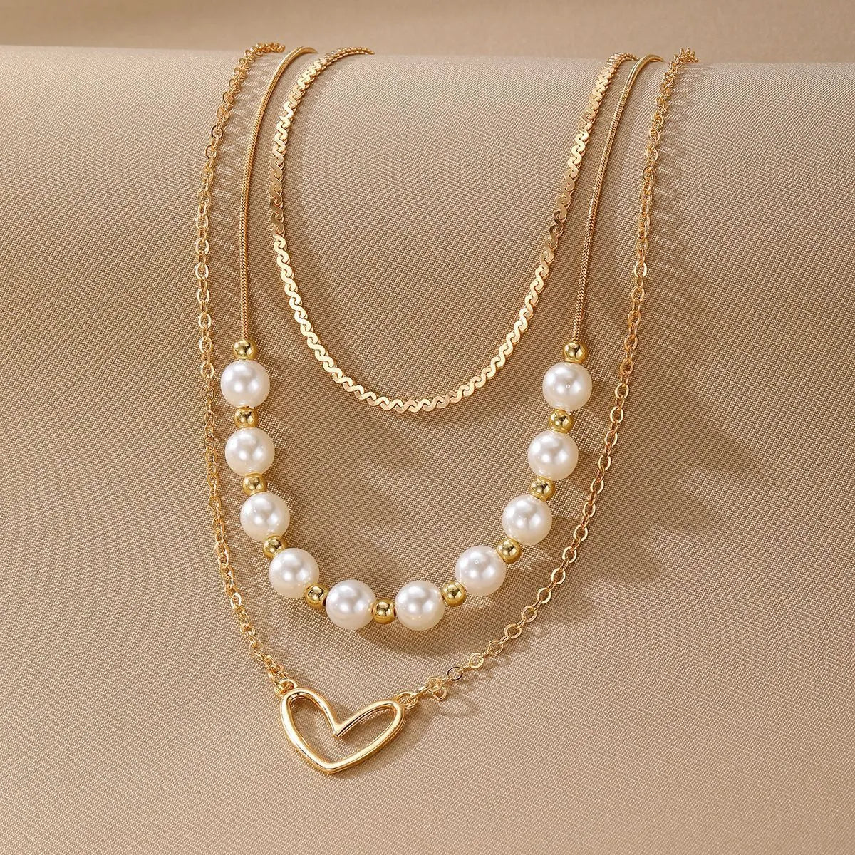 Vintage gold necklace with heart-shaped pendant on adjustable pearl-style chain