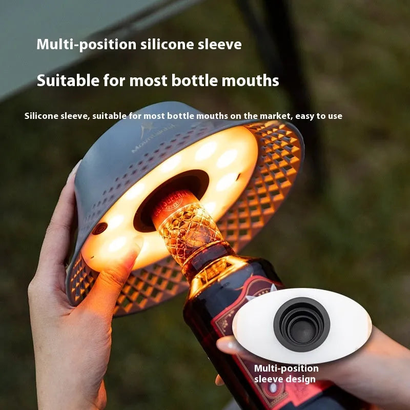 Beige wine bottle shaped camping lantern with USB-C port and control gear on top.