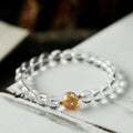 Geometric obsidian white crystal bracelet with black agate beads and golden dragon charm on wrist
