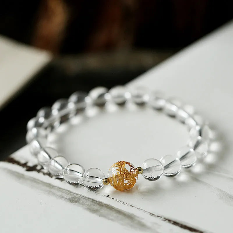 Geometric obsidian white crystal bracelet with black agate beads and golden dragon charm on wrist