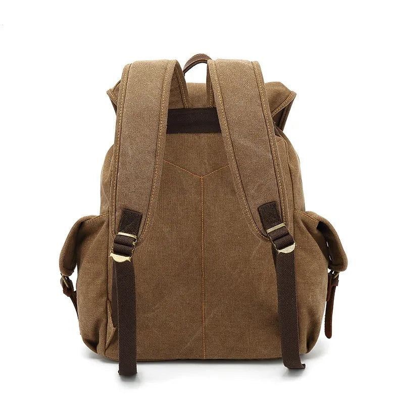 Retro military green canvas backpack with antique bronze hardware on a plain background.