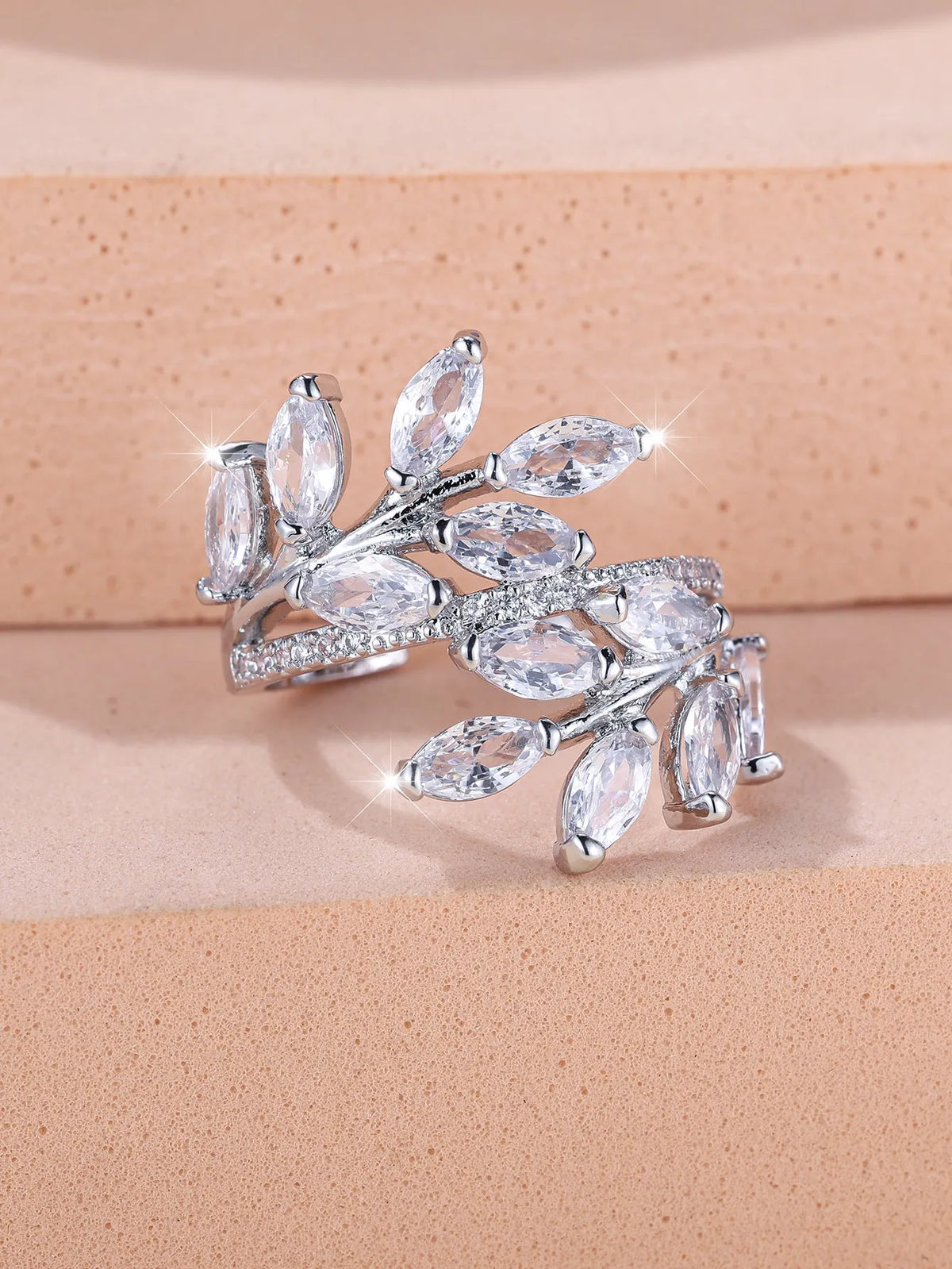 Adjustable copper leaf ring in platinum or rose gold finish on a white background