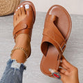 Women's flat heel leisure slippers in black artificial PU leather with metal and stitching detail, side view