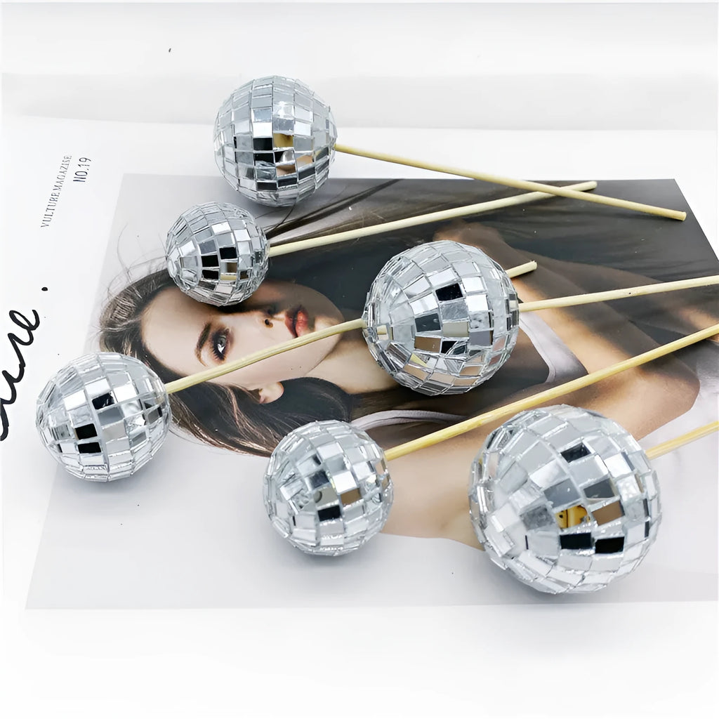 Glass disco ball cake decoration with wooden stick on a celebration cake