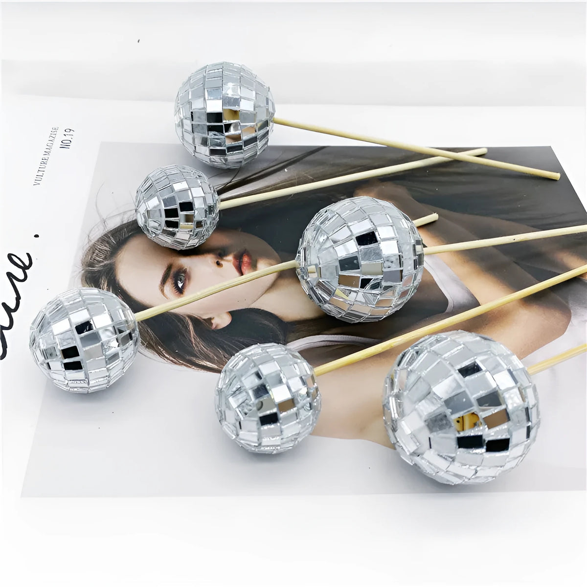 Glass disco ball cake decoration with wooden stick on a celebration cake