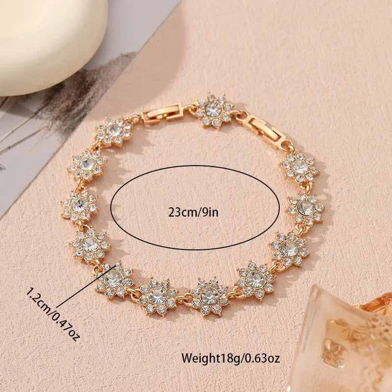 Gold and silver flower bracelet with colourful crystal and simulated diamond stones on a wrist.