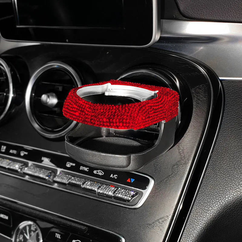 Car interior water cup bracket with decorative diamond accents mounted on air vent