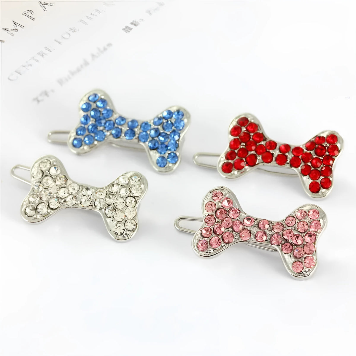 Rhinestone dog bone hair clip in alloy, shown in white, pink, blue, red and purple colour options.