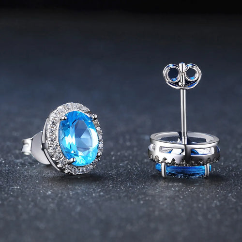 Geometric 925 sterling silver jewellery set with blue topaz stones, showing earrings, ring, pendant and necklace.