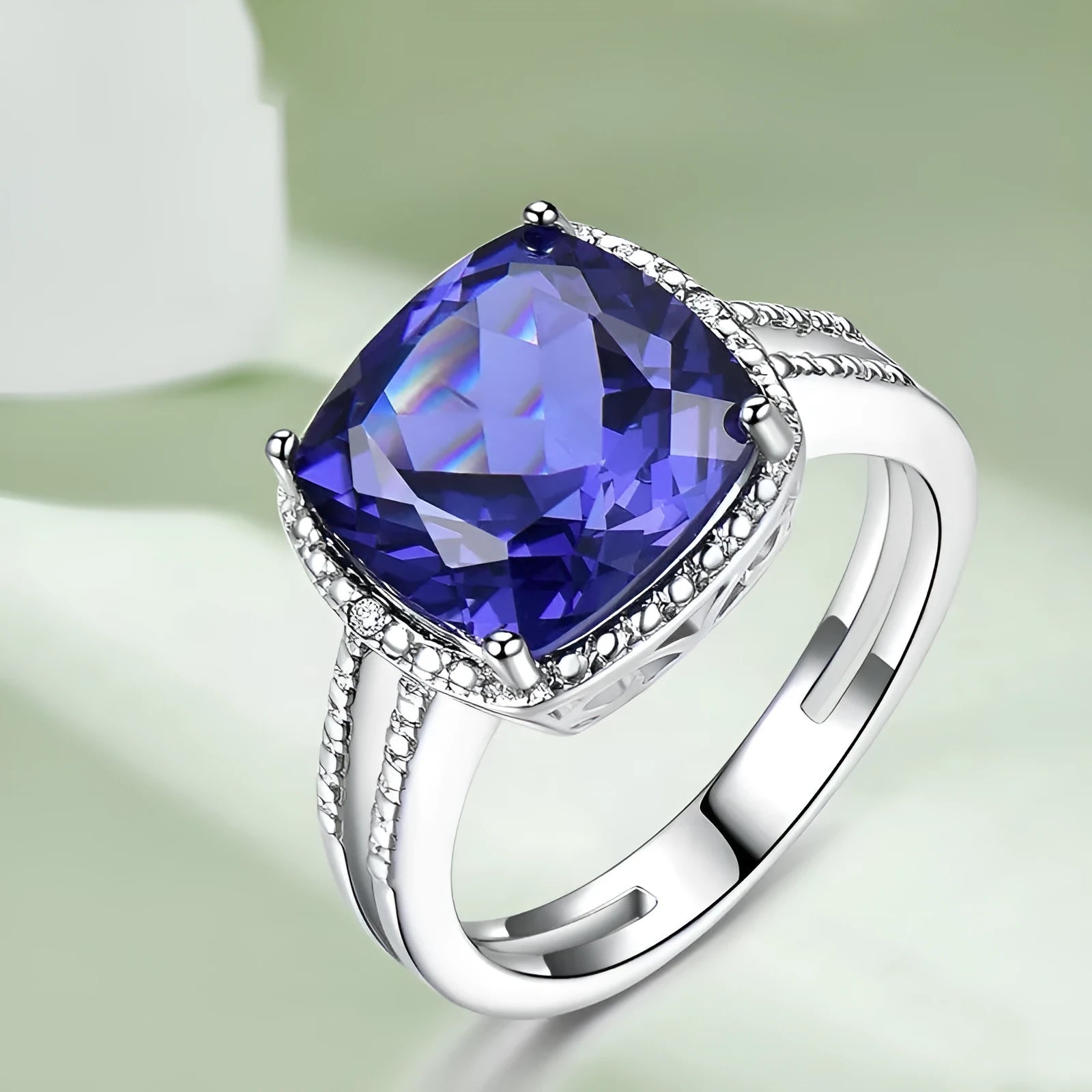 Blue tanzanite gemstone set in a silver women's ring on a finger.