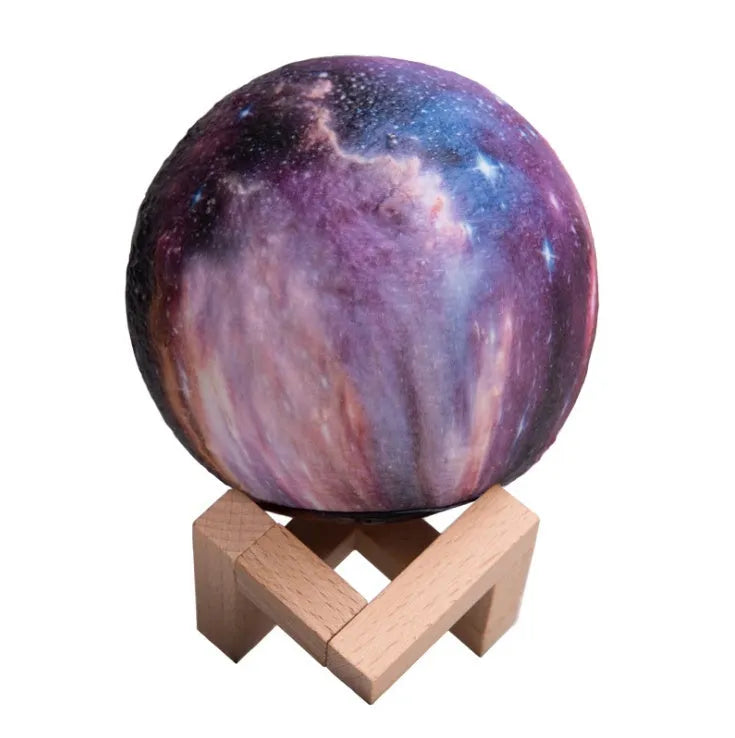 3D printed spherical moon night light glowing with multi-colour LED light on a dark surface.