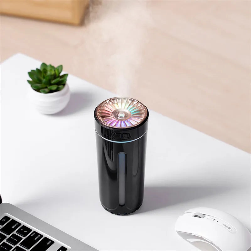 Black and white portable wireless humidifier with LED lights on a car cup holder and desktop
