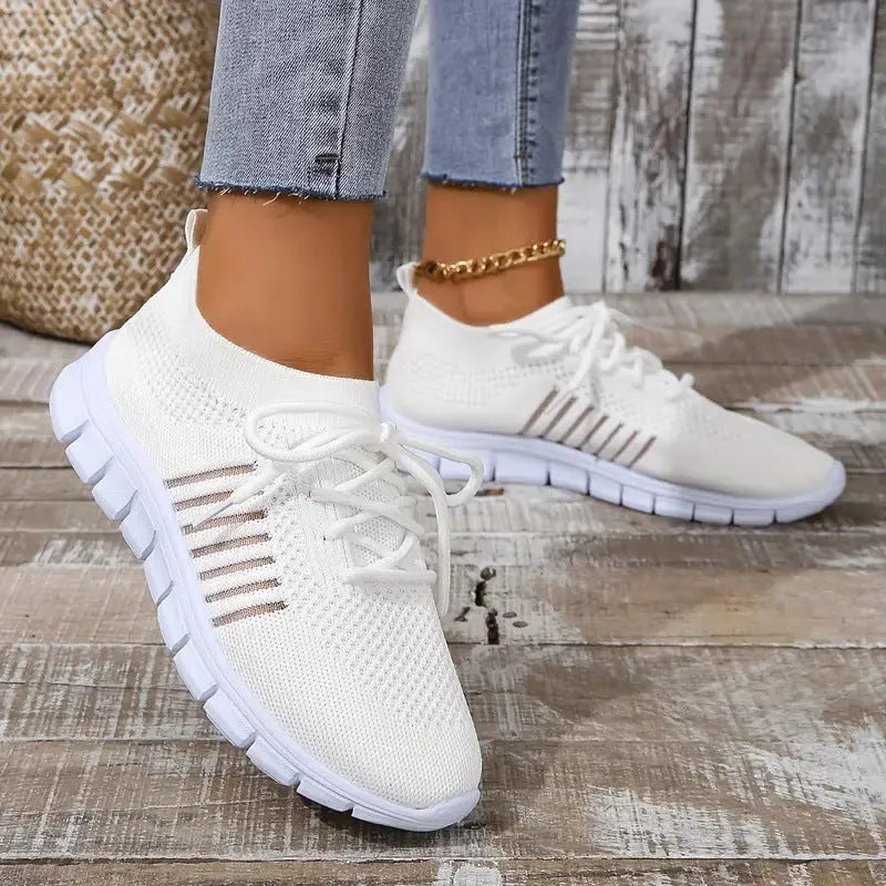 Women's casual flat shoes in beige with mesh upper and front-tie laces on a low EVA sole.