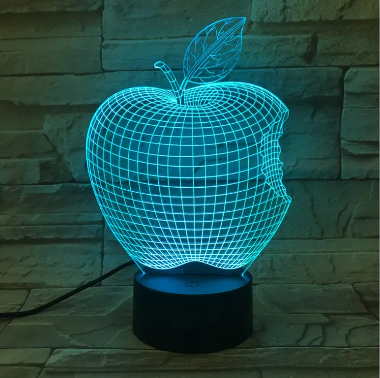 3D acrylic fruit-shaped night light with touch control and multi-colour LED illumination on a dark surface.