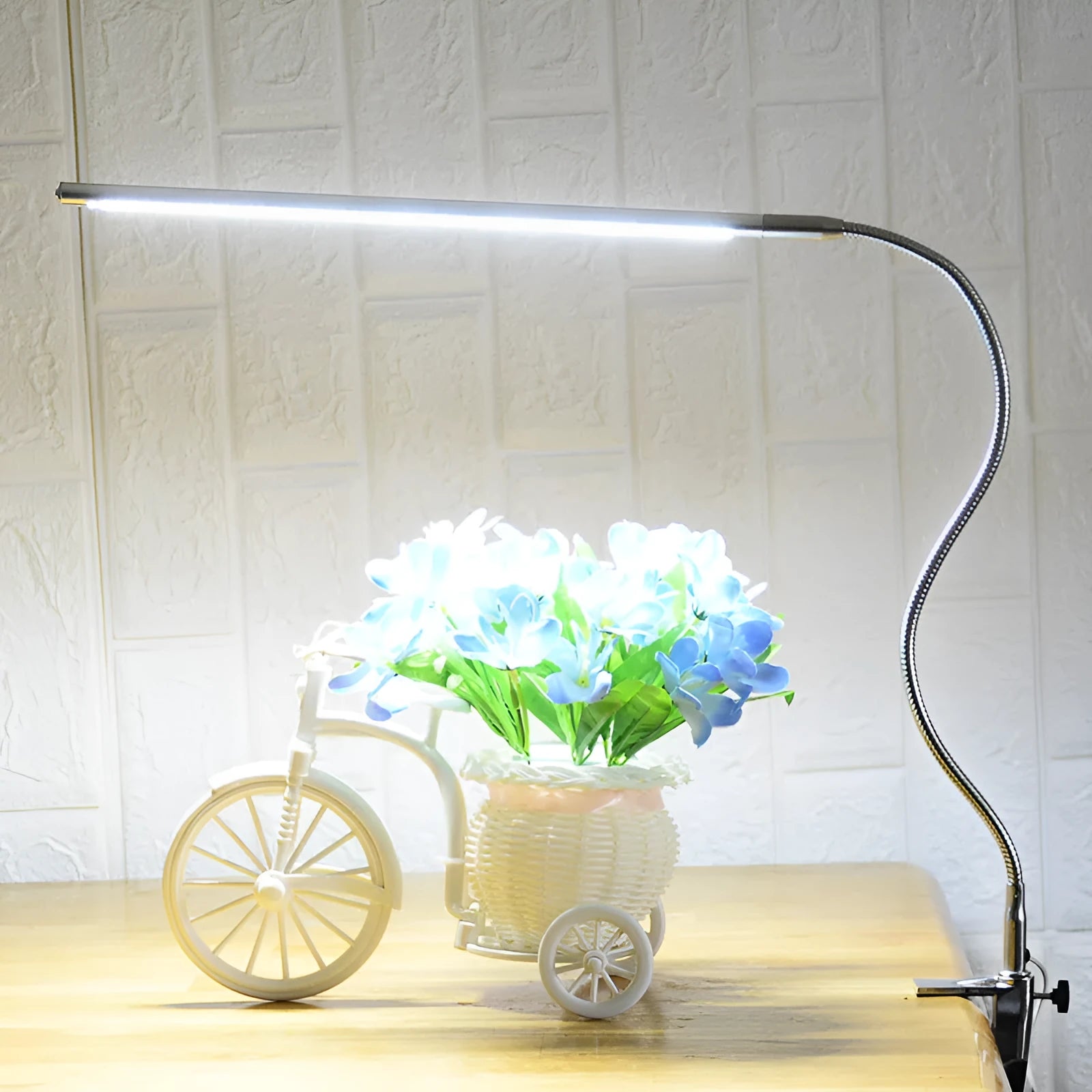 Silver LED clip-on table lamp with long arm extended, showing aluminium alloy construction and USB cable.