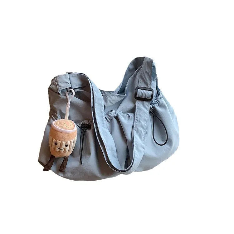 Ultra-light green pleated polyester crossbody bag showing split outer pocket and foldable design.