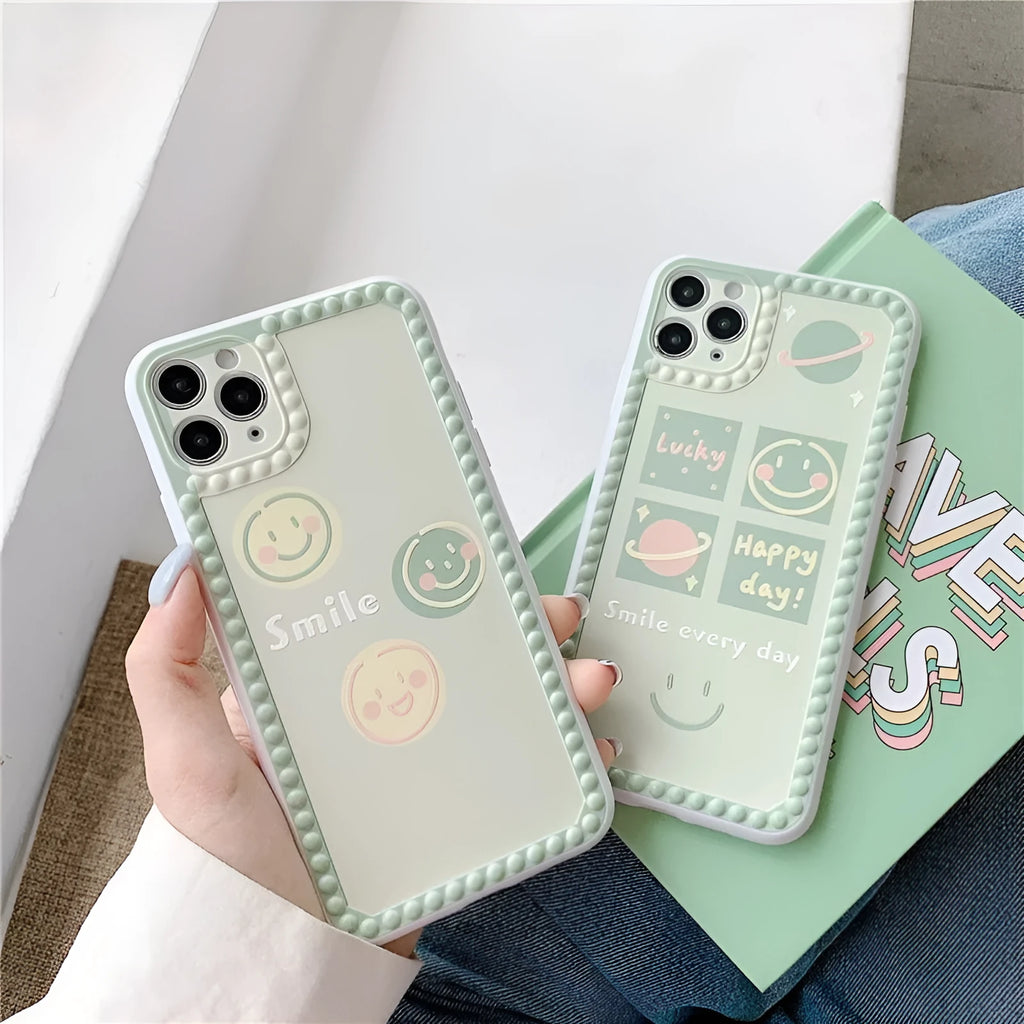 Green TPU iPhone case with a smiley face geometric pattern and polka dot frame.
