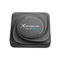 Compact black Android TV box with HDMI port, shown with remote control and power cable