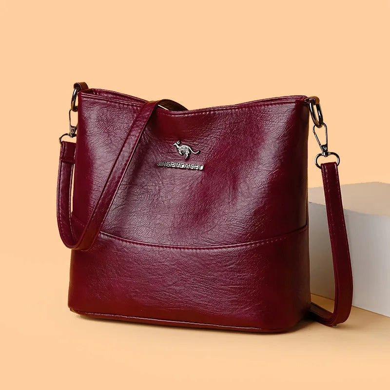 Women's casual soft leather bucket shoulder bag in black, wine red, or ginger yellow, showing large capacity and minimalist design.