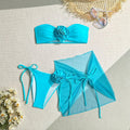 Women's pink swimsuit top with a large 3D flower tie and matching skirt set on a mannequin.