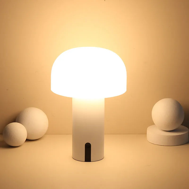 Decorative LED mushroom night light in green with warm white glow on a bedside table