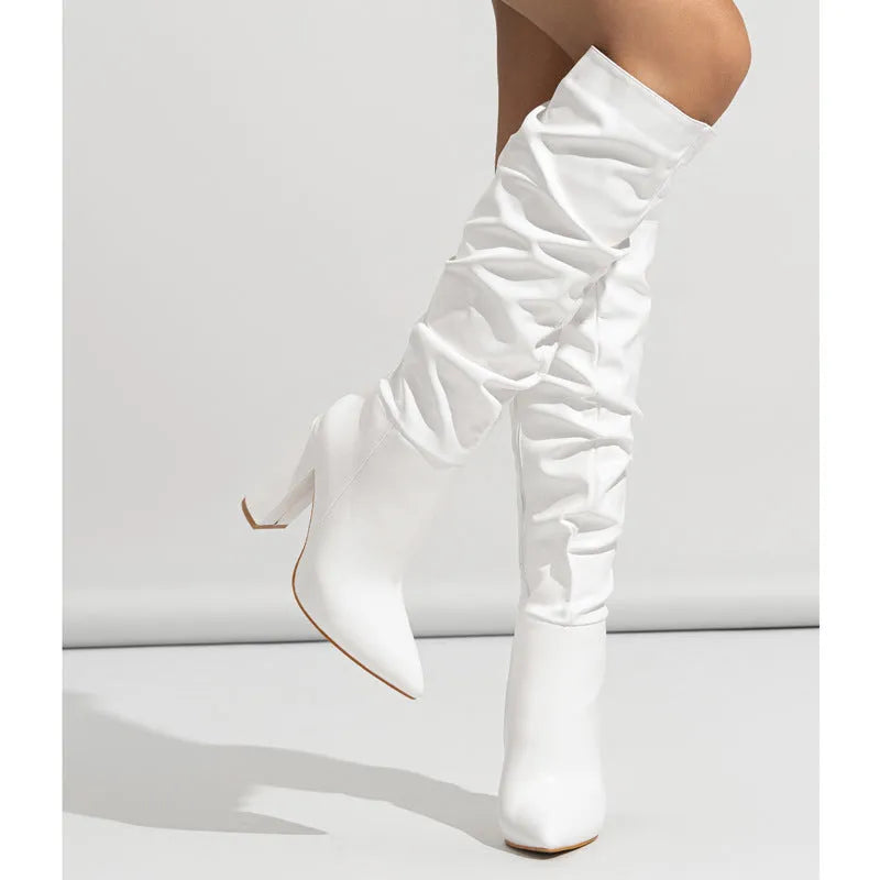 Women's white pointed toe high heel ankle boots with side zipper on a pink background