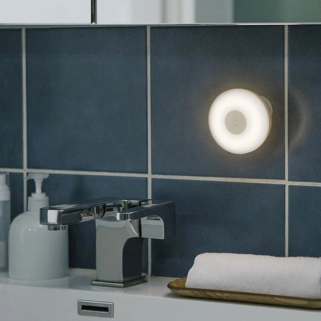 White Mijia Night Light 2 Bluetooth bedside lamp with human body induction on wooden table