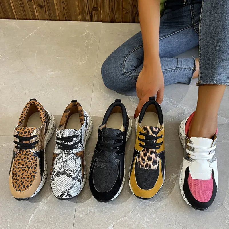 Women's black casual flat sneakers with suede upper and a wedge heel on a breathable fabric base.