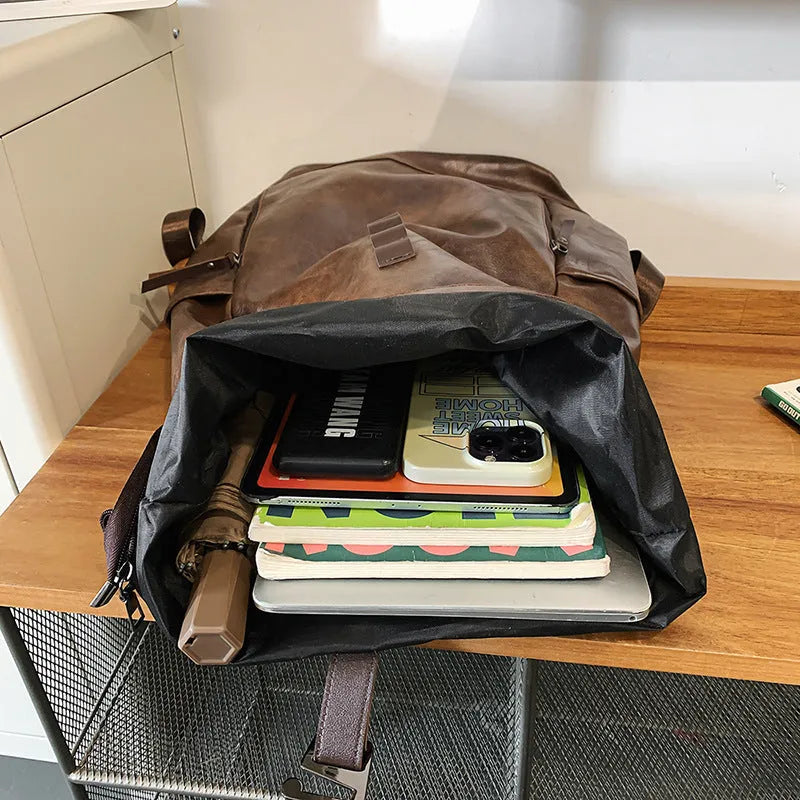 Large capacity PU leather backpack in black, solid colour, with curved shoulder straps and visible sewing line details