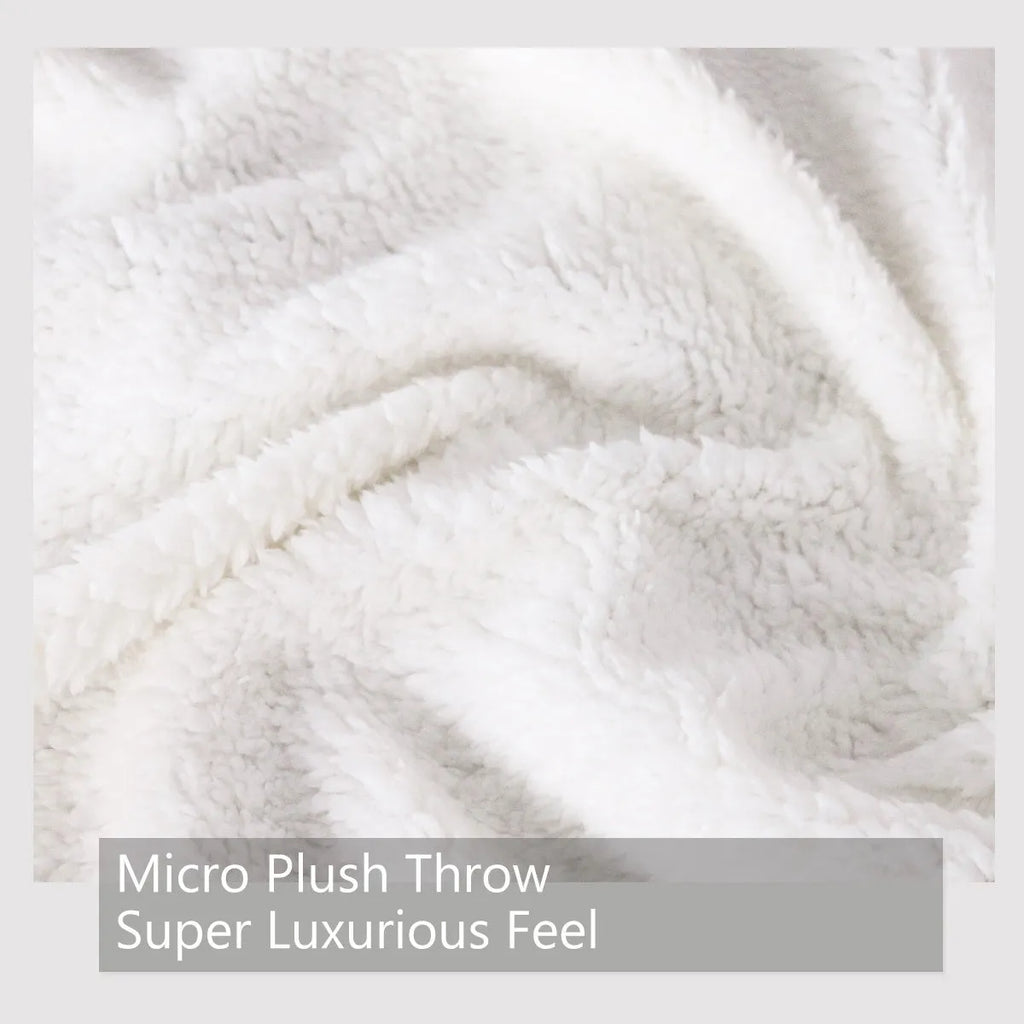 Multicoloured cat themed Sherpa fleece blanket 130x150cm with hemmed edges on a sofa