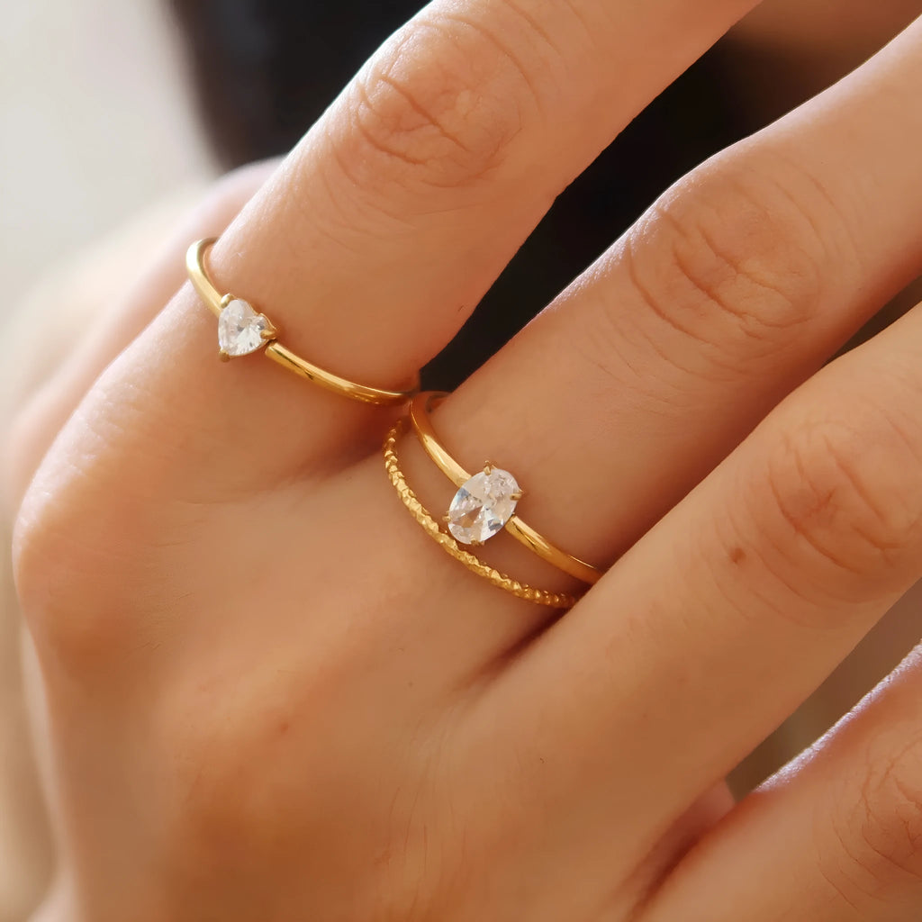 Simple golden stainless steel ring with either love heart or oval shape design in sizes 5 to 8