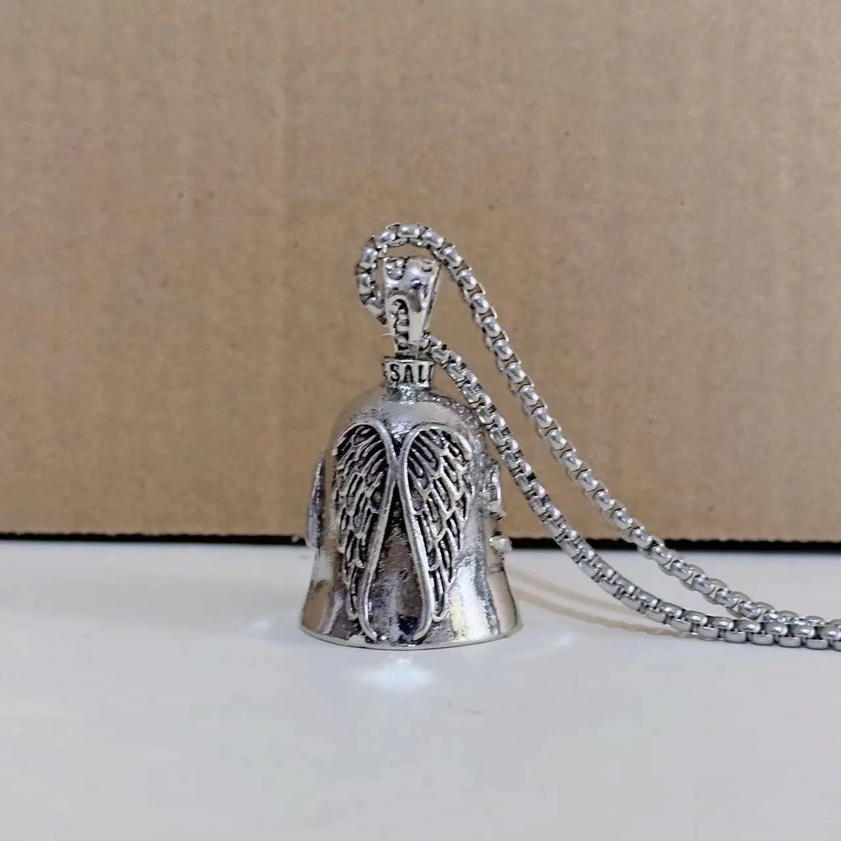 Vintage white angel feather wings alloy keychain and necklace set on a plain background.