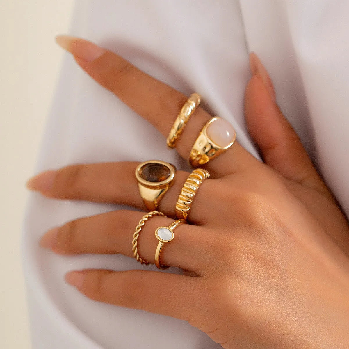 Set of six light gold geometric and round alloy stacking rings arranged together