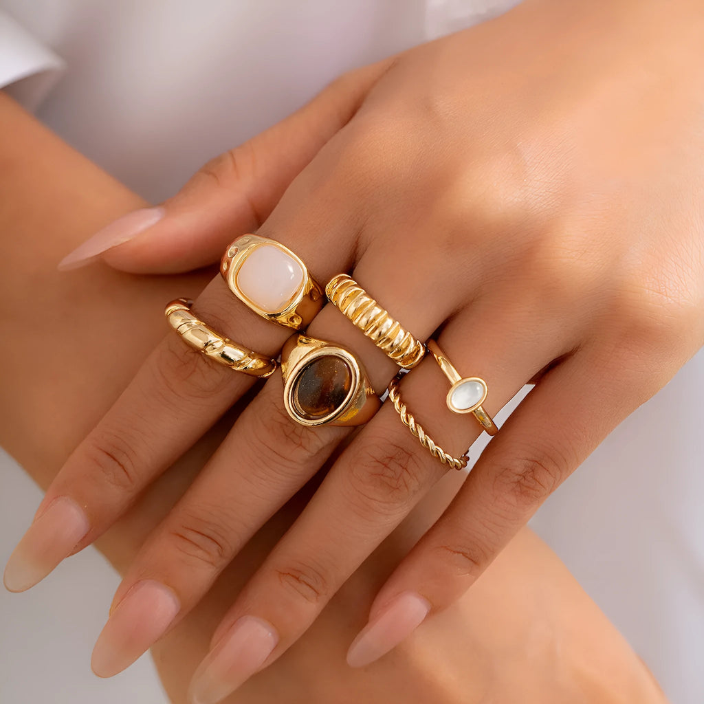 Set of six light gold geometric and round alloy stacking rings arranged together