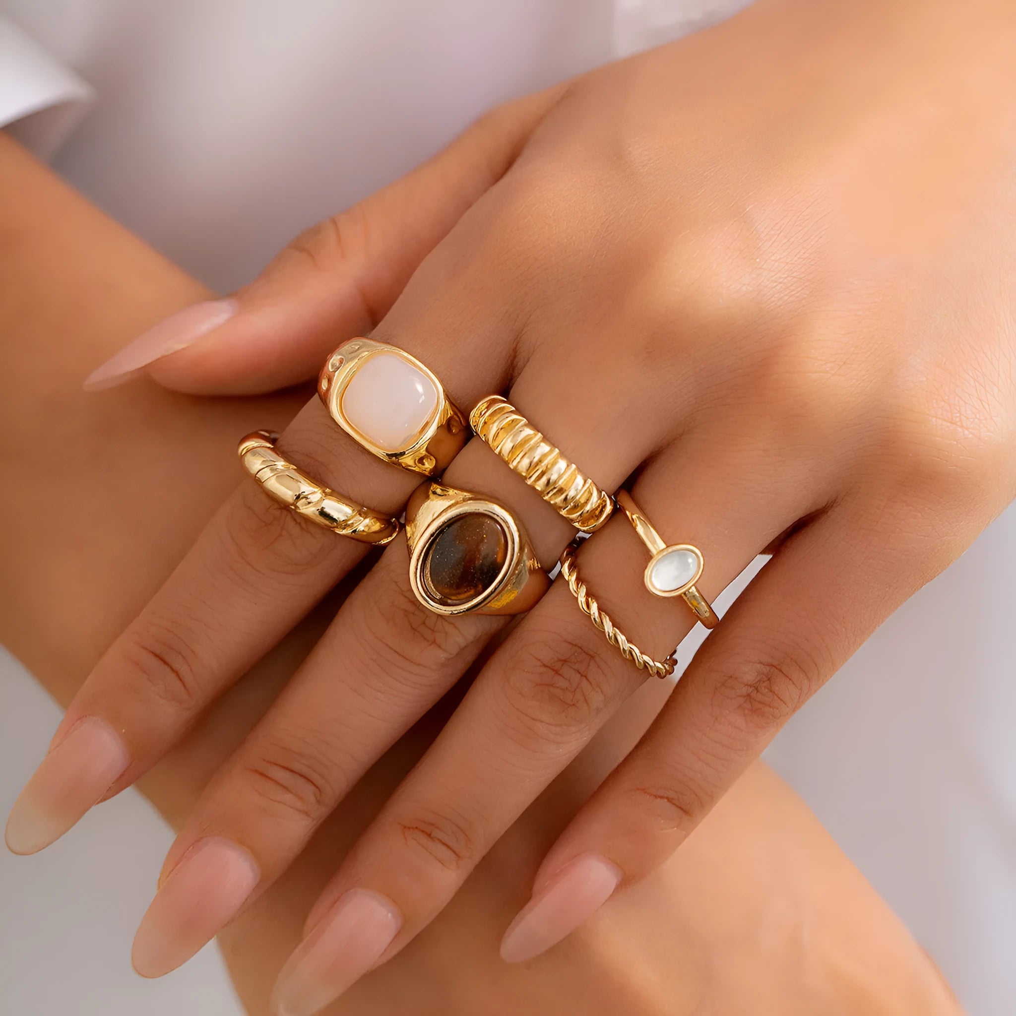 Set of six light gold geometric and round alloy stacking rings arranged together