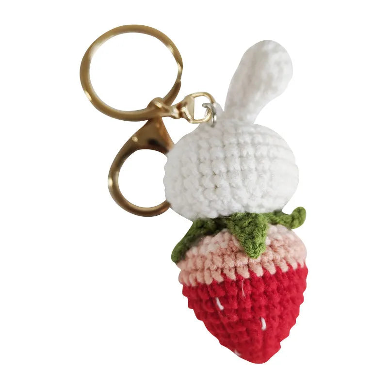 White hand-woven wire pendant charm with a cartoon rabbit and strawberry design on a key hook.
