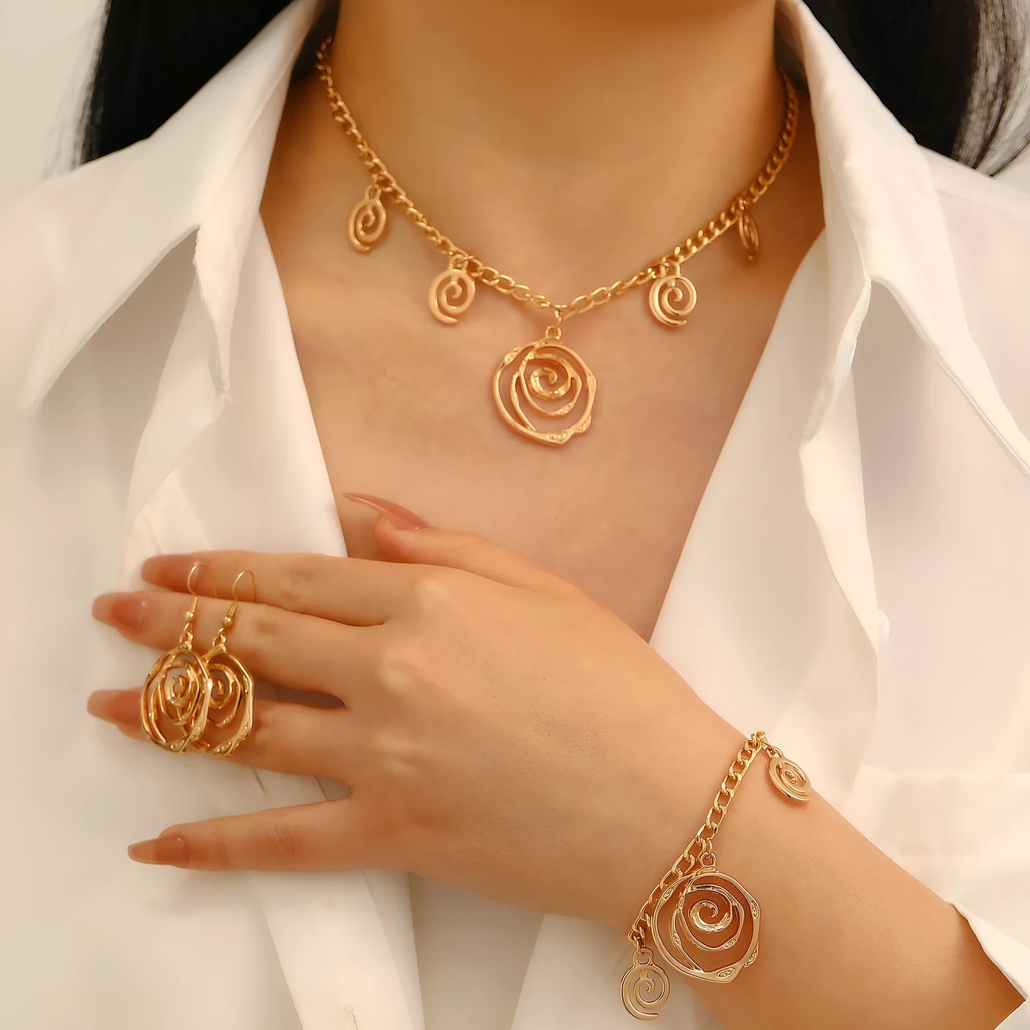 Women's spiral donut jewellery set showing necklace, bracelet and earrings in gold finish