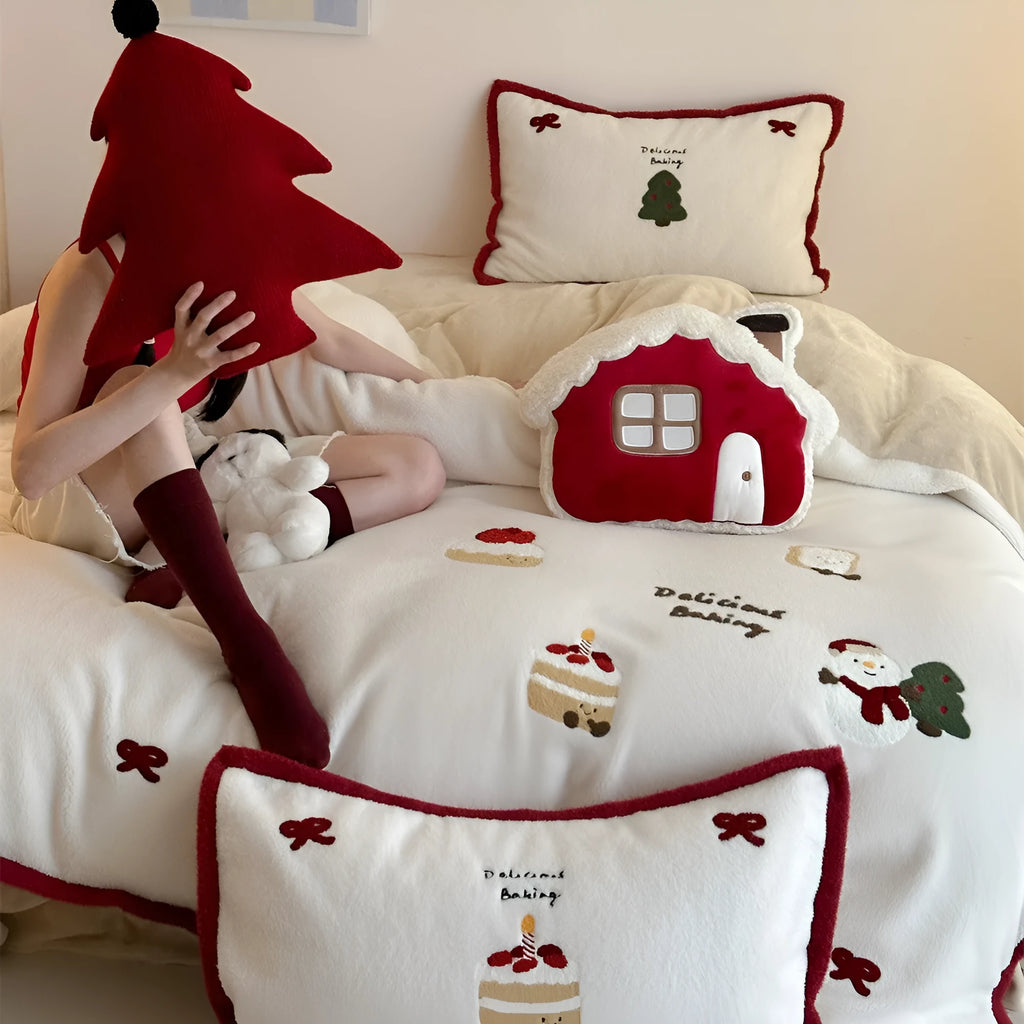 Winter Christmas cartoon patterned four-piece bedding set showing duvet cover, bed sheet, and pillowcases on a bed.